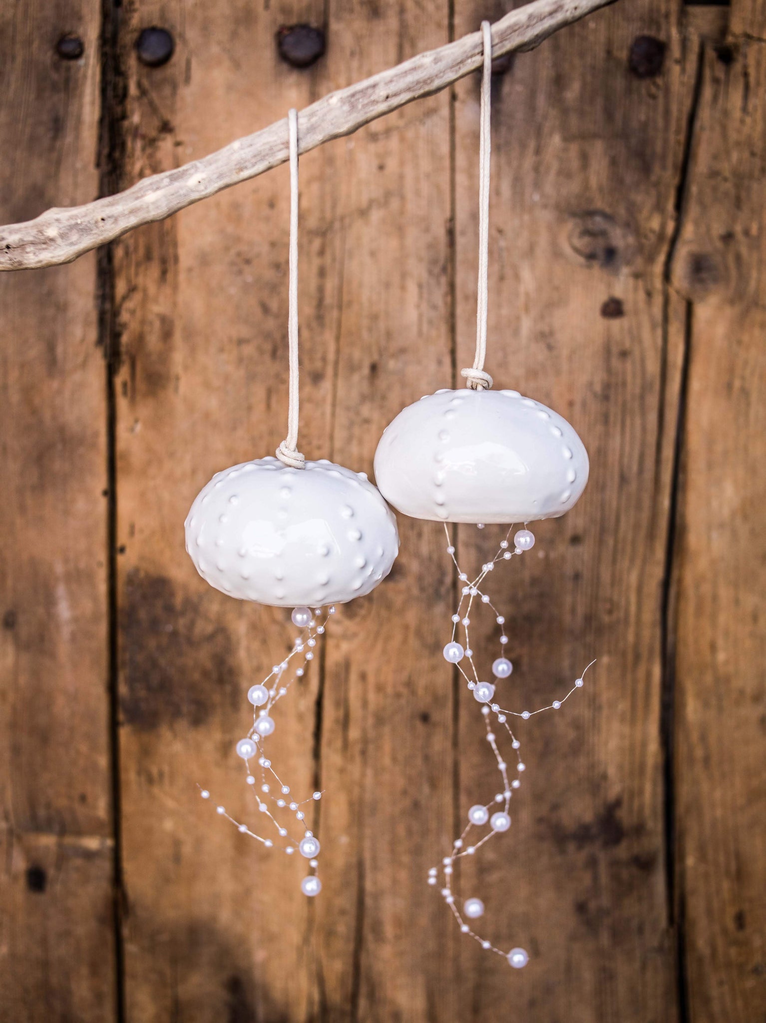 Movil meduza en esmalte blanco con perlitas que cuelgan 